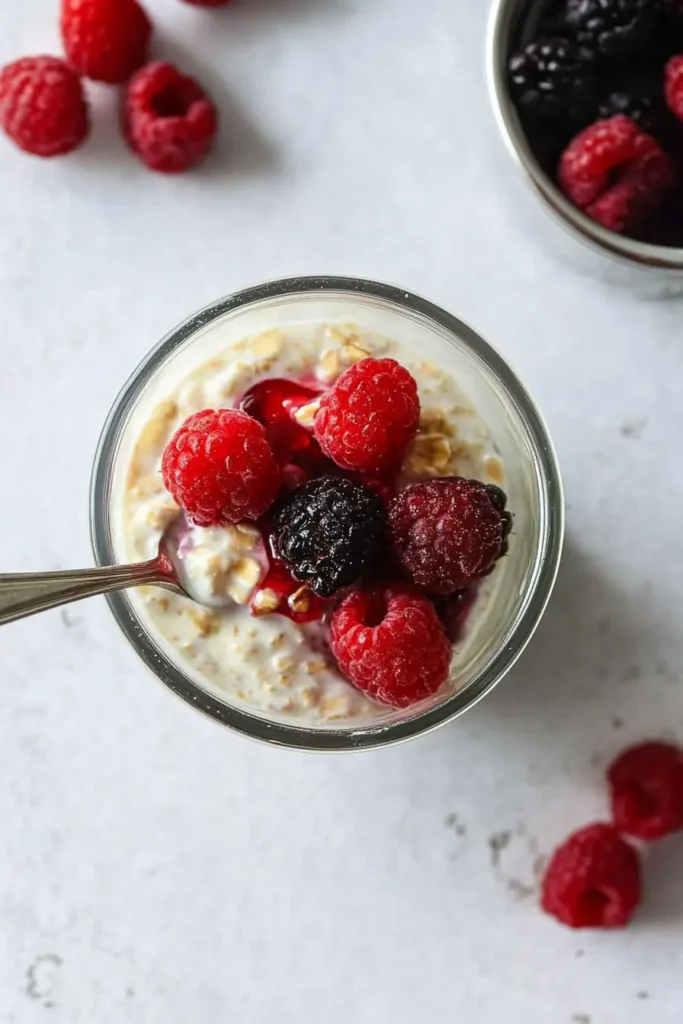 Cottage Cheese Overnight Oats: The Creamiest, Easiest Breakfast You’ll Love 7 Adding fresh and frozen berries to Cottage Cheese Overnight Oats jar